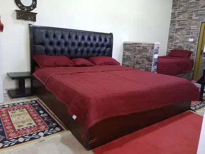 a bedroom with a large bed with a red bedspread at family studio in Wadi Musa