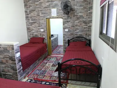 a bedroom with two beds and a mirror at family studio in Wadi Musa