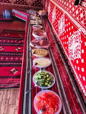 a long table with plates of food on it at Wadi Rum Desert Stars in Wadi Rum