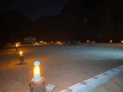 a lit candle in the middle of a beach at night at Allen Luxury Wadi Rum in Wadi Rum