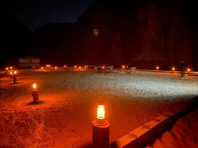 a group of candles in the sand at night at Allen Luxury Wadi Rum in Wadi Rum