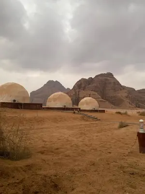 a group of domes in a desert with mountains at Allen Luxury Wadi Rum in Wadi Rum