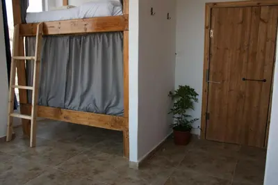 a bedroom with a bunk bed with a ladder and a door at The Castle Star in Amman