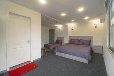 a bedroom with two beds and a red rug at The Castle Star in Amman