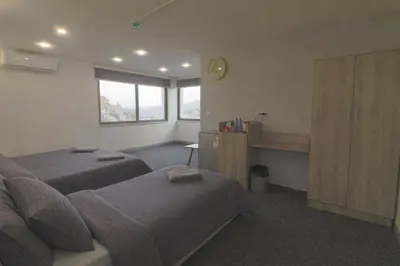 a bedroom with two beds and a clock on the wall at The Castle Star in Amman