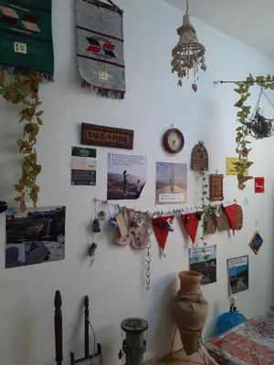 a white wall with a bunch of pictures and magnets at Beit alkaram in Kerak