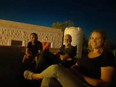 a group of three people sitting on a wall at Beit alkaram in Kerak