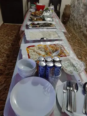 a long table filled with food and plates and utensils at Beit alkaram in Kerak