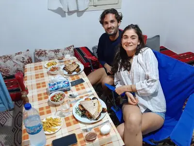 a man and a woman sitting at a table with food at Beit alkaram in Kerak