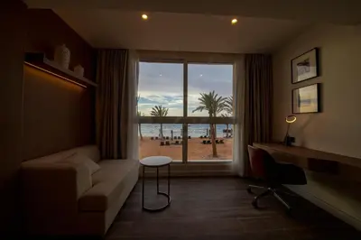 a living room with a couch and a large window at Luxotel Aqaba Beach Resort & Spa Only 15 years plus in Aqaba