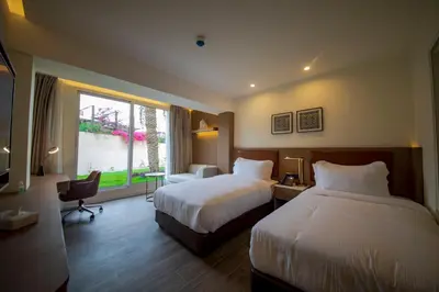 a hotel room with two beds and a window at Luxotel Aqaba Beach Resort & Spa Only 15 years plus in Aqaba