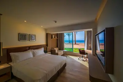 a bedroom with a bed and a large window with the ocean at Luxotel Aqaba Beach Resort & Spa Only 15 years plus in Aqaba