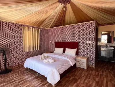 a bedroom with a bed with two cats laying on it at Wadi rum under stars in Wadi Rum