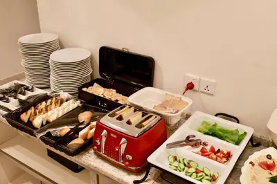 a kitchen counter with a bunch of food and plates at Luciana Hotel by FHM in Aqaba