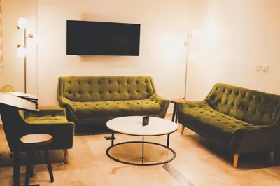 a living room with two green couches and a table at Luciana Hotel by FHM in Aqaba