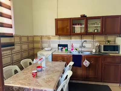a kitchen with a table with chairs and a sink at IBN Khaldoon in Madaba