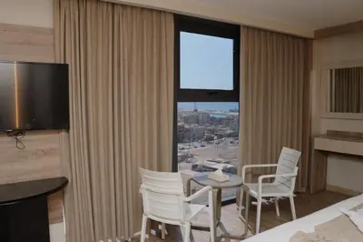 a hotel room with a table and chairs and a large window at ALENA HOTEL in Aqaba