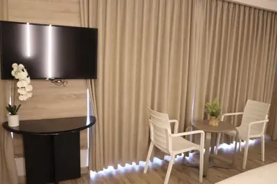a room with a table and chairs and a television at ALENA HOTEL in Aqaba