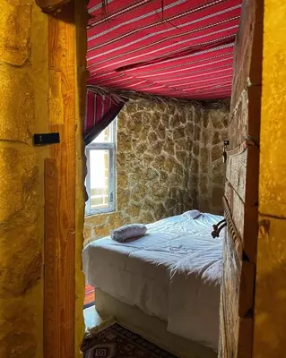 a bedroom with a bed in a room with a window at 7 Caves Hotel in Al Jāyah