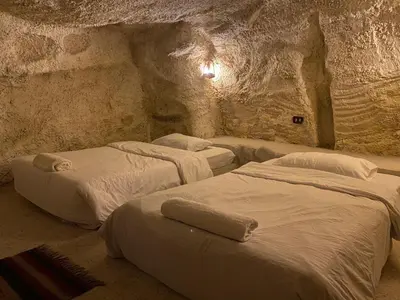 a room with three beds in a cave at 7 Caves Hotel in Al Jāyah