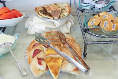 a table topped with plates of pastries and utensils at Khuttar Apartment in Amman