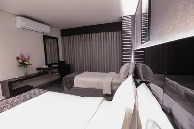a hotel room with two beds and a desk at Khuttar Apartment in Amman