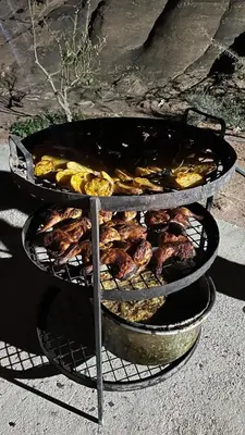 two trays of food on top of a grill at Night Magic Camp in Wadi Rum