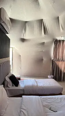 two beds in a hotel room with white sheets at Night Magic Camp in Wadi Rum
