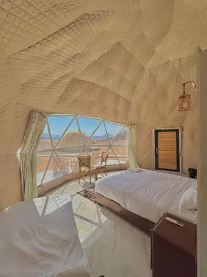 a bedroom with two beds and a view of the desert at Night Magic Camp in Wadi Rum