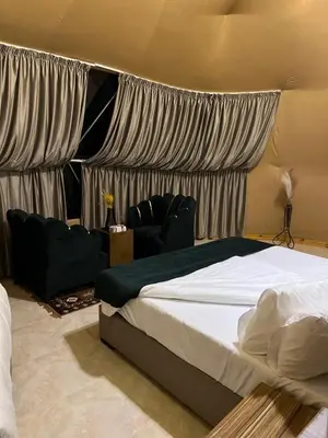 a bedroom with a bed with curtains and a couch at Kylie magic camp in Wadi Rum
