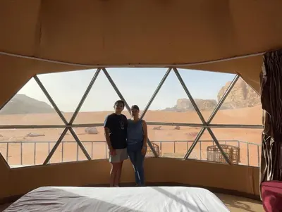 a man and woman standing in a room with a window at Kylie magic camp in Wadi Rum
