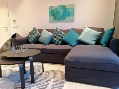 a living room with a brown couch and blue pillows at Blue Diamond Ayla - Restricted to Family stays in Aqaba