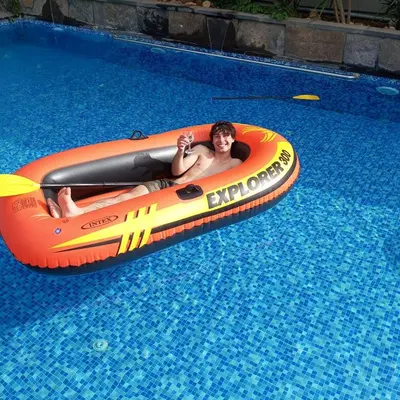 a man is laying in an orange raft in a swimming pool at laperla chalet villa di lusso deadsea in Sowayma