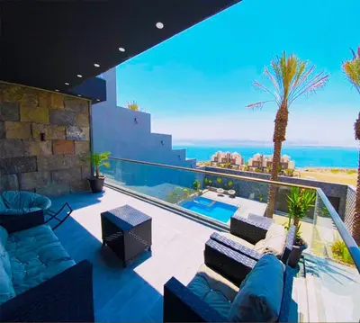 a balcony with blue furniture and a view of the ocean at laperla chalet villa di lusso deadsea in Sowayma