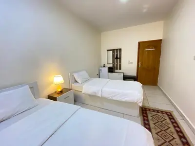 a bedroom with two beds and a lamp on a table at Rose city inn in Wadi Musa