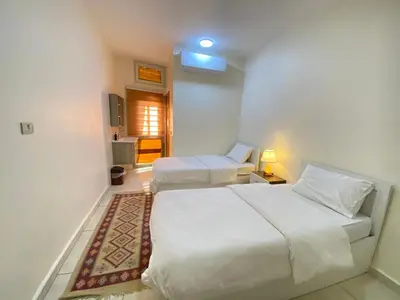 a bedroom with two beds and a living room at Rose city inn in Wadi Musa