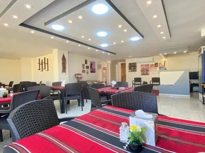 a restaurant with red and black tables and chairs at Rose city inn in Wadi Musa