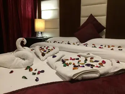 two beds with towels and a swan on the bed at Uptown Hotel Apartment in Amman