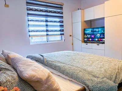 a bedroom with a bed and a tv and a window at Full panorama Jerash (PLUS) in Jerash