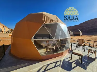 a tent with chairs and a table in a desert at SARA lUXURY CAMP in Wadi Rum