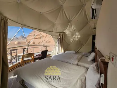 a bedroom with two beds and a view of the desert at SARA lUXURY CAMP in Wadi Rum