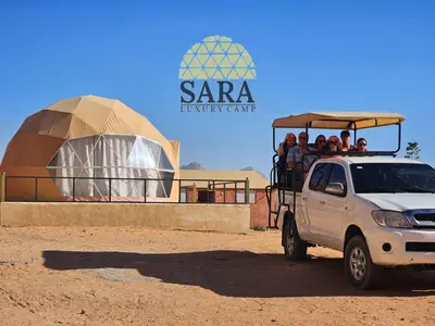 a group of people riding in the back of a white truck at SARA lUXURY CAMP in Wadi Rum