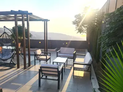a patio with chairs and tables on a balcony at Zoom Chalets in Amman