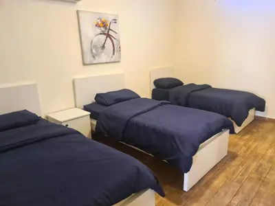 a room with three beds and a painting on the wall at Zoom Chalets in Amman