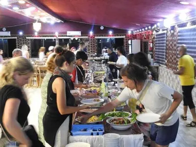 a group of people preparing food at a buffet at The sun of Wadi Rum camp in Wadi Rum