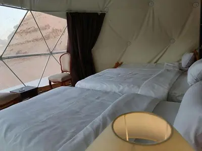 a tent bedroom with two beds and a window at The sun of Wadi Rum camp in Wadi Rum