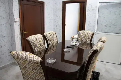a table with chairs and a mirror in a room at Blue House in Aqaba