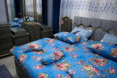 a bedroom with a blue comforter and pillows on a bed at Blue House in Aqaba