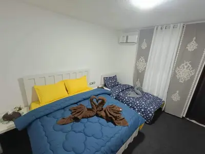 a bedroom with a blue bed with yellow pillows at petra Casablanca lodge in Wadi Musa