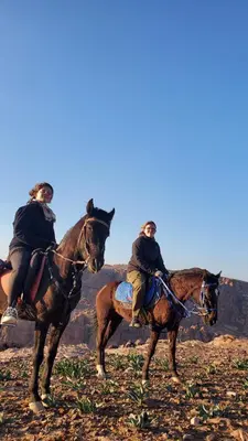 two people riding on horses in the desert at petra Casablanca lodge in Wadi Musa